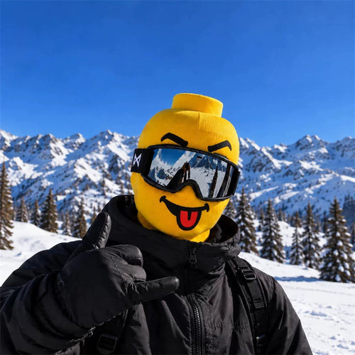 Blockhead ski mask, Tongue Out face, worn with ski goggles on a snowy mountain
