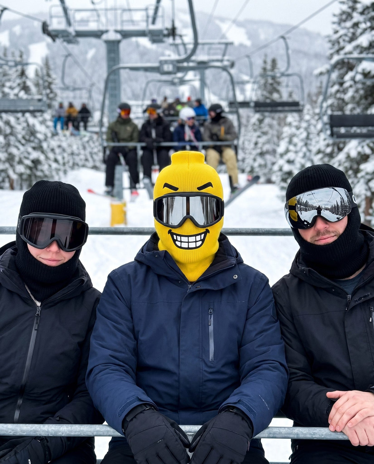 Blockhead Chomp ski mask between two plain black balaclavas on a chairlift
